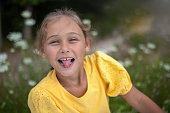 Little girl kid showing tongue at camera outdoor