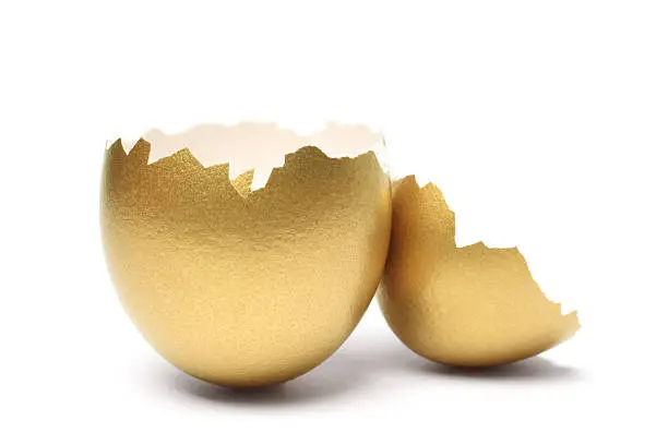 "Empty golden egg shells, isolated on white background."