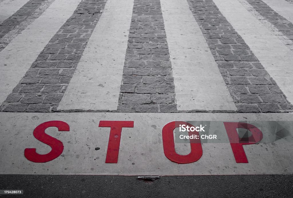 STOP STOP written on the street in front of a zebra crossing. Brick Stock Photo