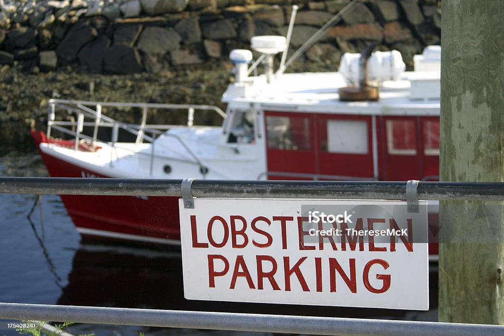 Lobster Boat on Maine Inlet Parking sign for lobstermen only.  A red lobster boat prepares to leave a Maine inlet at Perkins Cove. Lobster - Animal Stock Photo