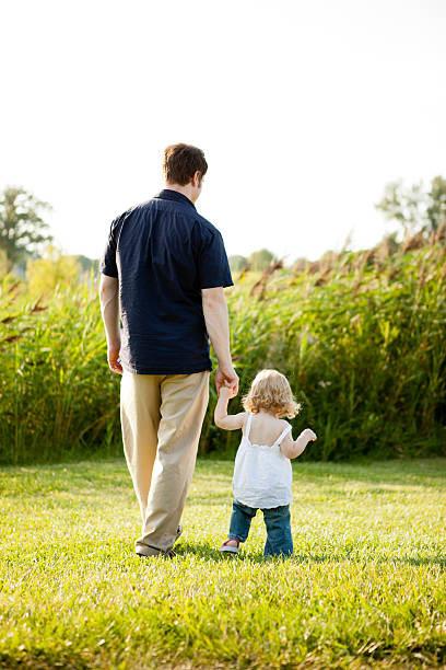 istock Father Holding His Toddler Daughter's Hand While Walking Outside 175428305