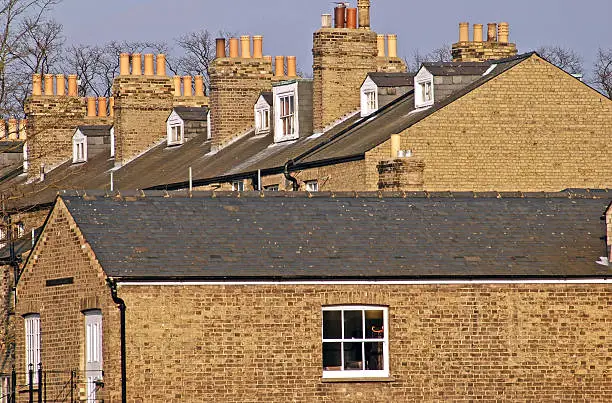 "Brick rowhouses with chimney pots in late light in Cambridge, England"