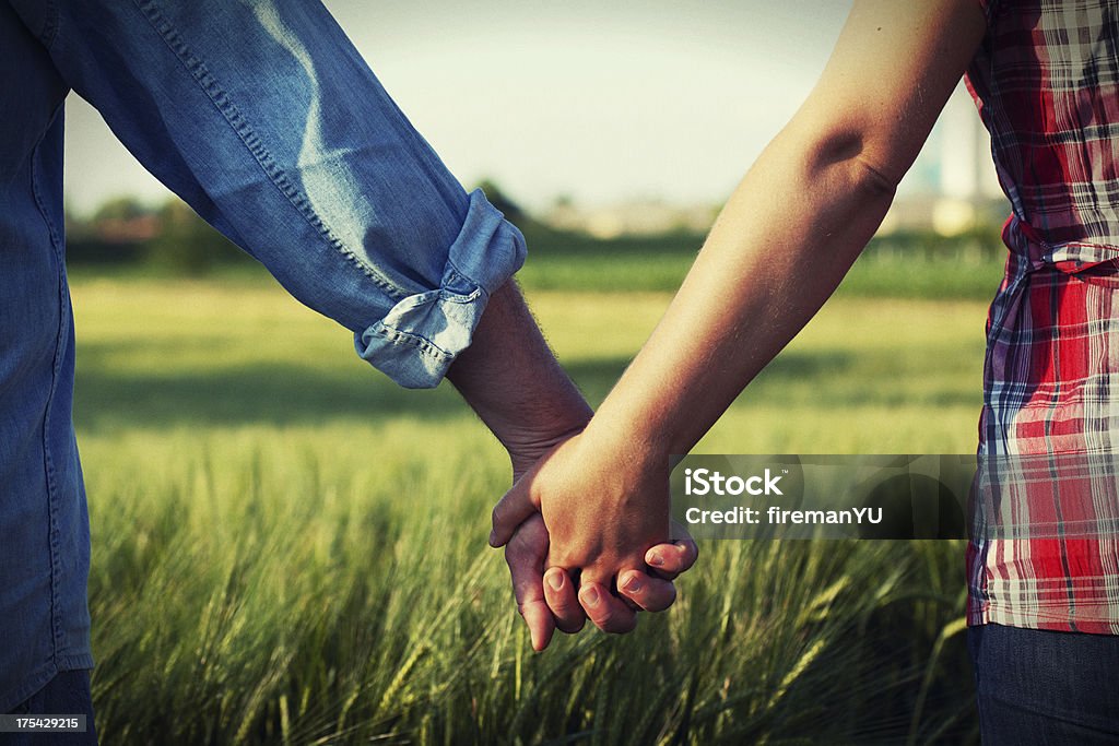 Coppia tenendo le mani - Foto stock royalty-free di Campo