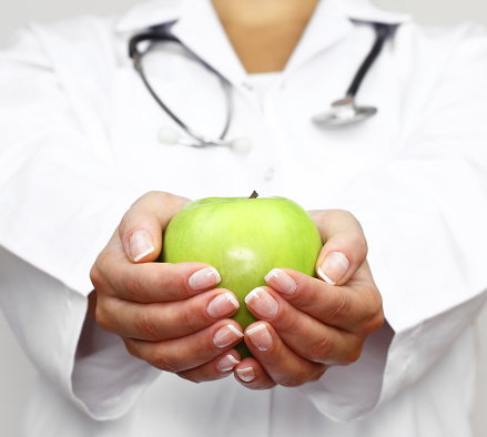 Doctor holds green apple