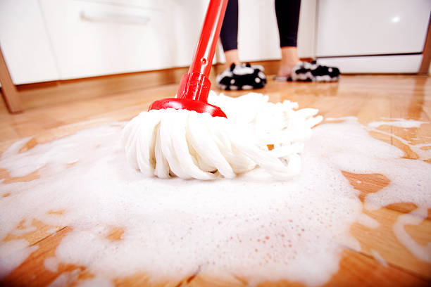 donna di lavare i pavimenti in legno - cleaning domestic kitchen white duster foto e immagini stock