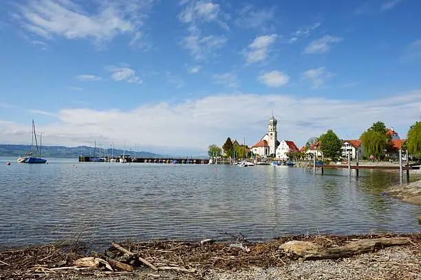 Wasseburg is a small Bavarian village on the german side of Lake Constance. View to harbor and the Church of St-George. These are the main landmarks of the small and pitoresque peninsula. In background there are the mountains of the Switzerland side of Lake Constance.Lake Constance