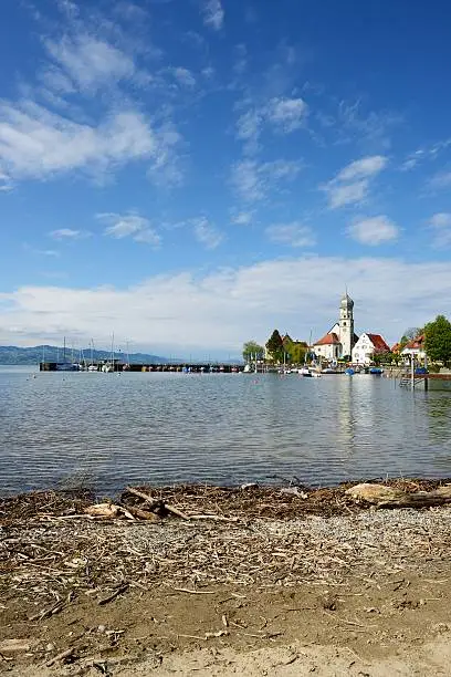 Wasseburg is a small Bavarian village on the german side of Lake Constance. View to harbor and the Church of St-George. These are the main landmarks of the small and pitoresque peninsula. In background there are the mountains of the Switzerland side of Lake Constance.