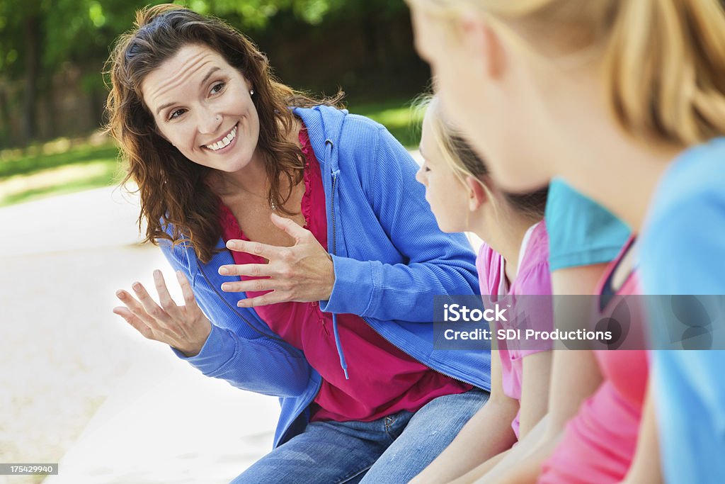 Woman mentoring group of girls at a park Adolescence Stock Photo