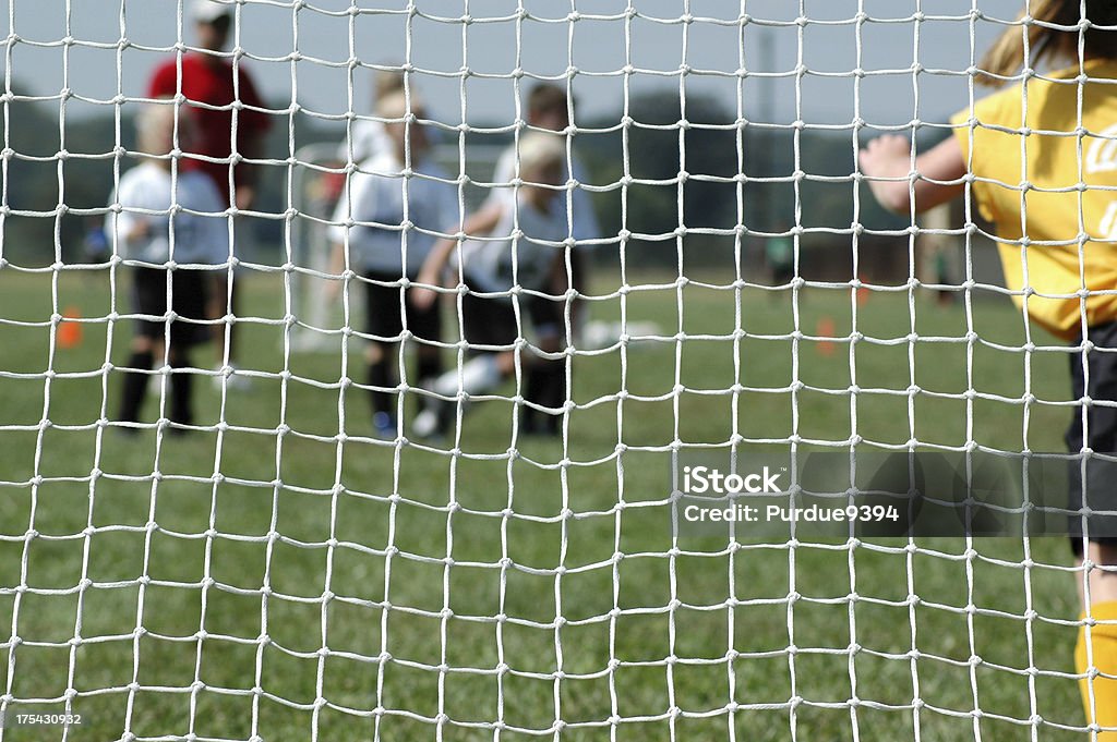 Youth Soccer - Defending the Goal Female soccer goalie defending the goal in a youth co-ed soccer game.  Focus intentionally on the net strings. Active Lifestyle Stock Photo