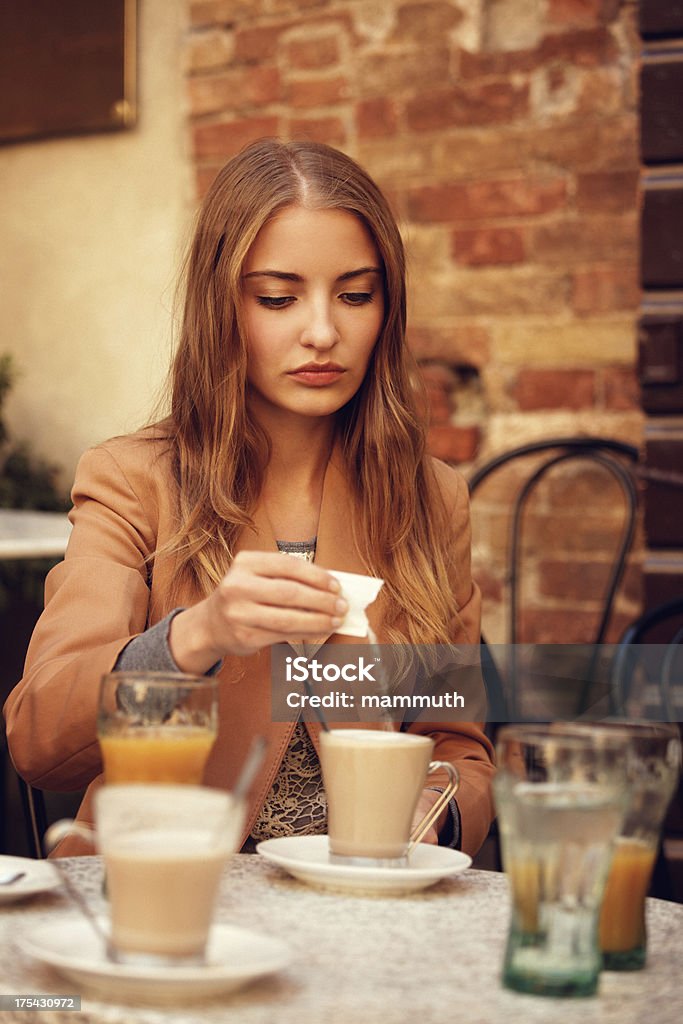 Chica en un café con leche Verter azúcar - Foto de stock de 20 a 29 años libre de derechos