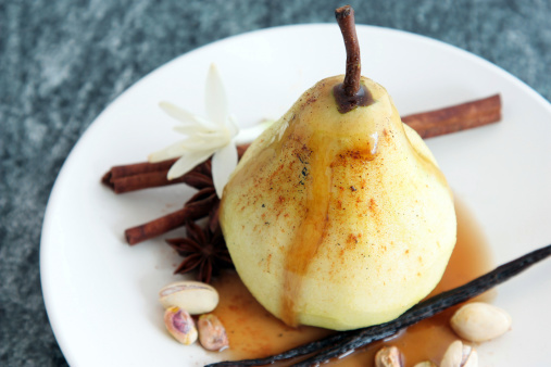 A sweet dessert of poached pear in vanilla syrup, spiced with cinnamon, star anise and pistachio nuts.