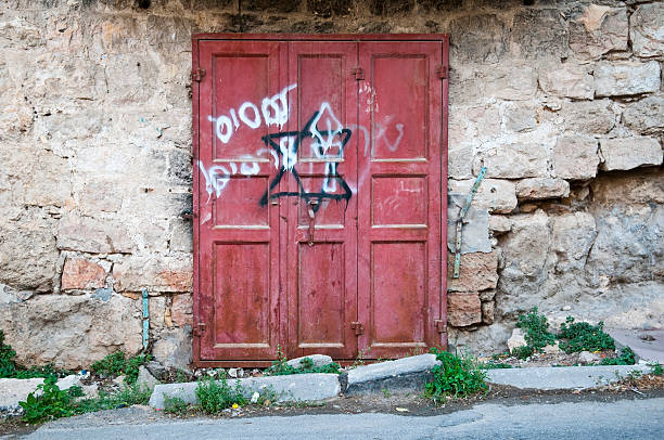 Graffiti left by Israeli settlers on the door of an old Palestinian home or business in the old city of Hebron in the West Bank