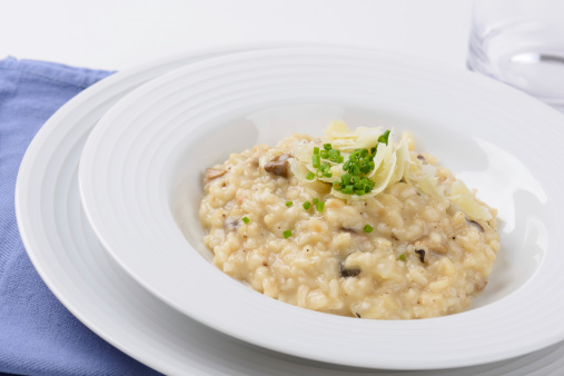 Fresh bowl of hot Risotto with fresh slices of Parmesan Cheese.  Captured as a 14-bit Raw file. Edited in 16-bit ProPhoto RGB color space.