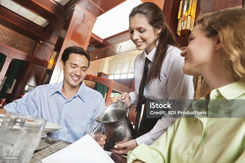 Happy garçonete posterior reenchimento, bebidas em nice restaurante - Foto de stock de Encher royalty-free