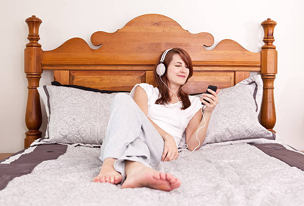 istock Woman Lying In Bed Listeing to MP3 Player 175432210