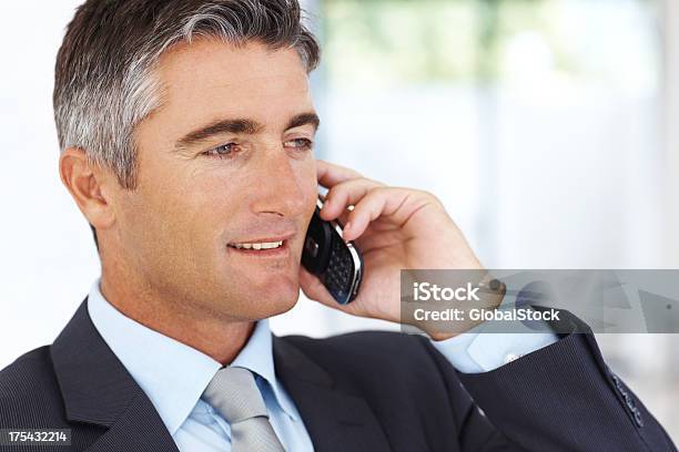 Middleaged Man Attentively Listening To Colleague On Phone Stock Photo - Download Image Now