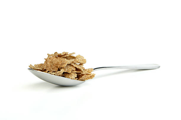 Bran 1 Spoonful of bran cereal, isolated on white background. bran flakes stock pictures, royalty-free photos & images