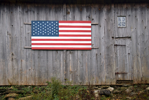 Wooden USA stars and stripes flag on an old barn made out of old planks.