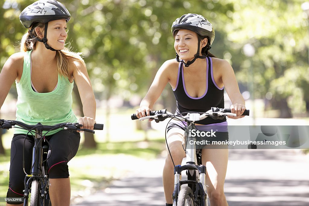 Zwei Frauen, die Radfahren durch den Park - Lizenzfrei Aktiver Lebensstil Stock-Foto