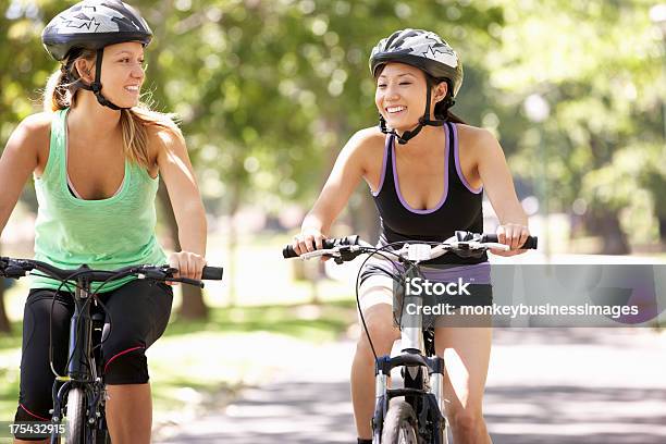 Dwie Kobiety Na Rowerze Przez Park - zdjęcia stockowe i więcej obrazów 20-29 lat - 20-29 lat, Aktywny tryb życia, Bicykl