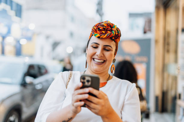 istock Smiling woman using smartphone in the city 1754329168