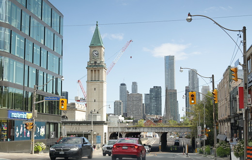 Toronto, Canada - August 27, 2023: A clock tower stands near an elevated railway bridge south on Yonge Street. Afternoon in the Rosedale and Summerhill neighbourhoods.