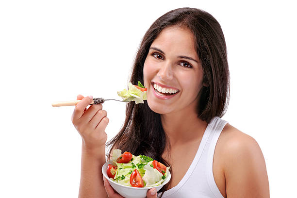 istock Young smiling woman eating salad 175434296