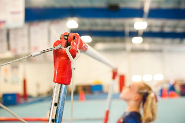 Young female gymnast on the uneven bars  stock photo