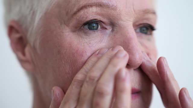 Close up Portrait of Positive Elderly Woman Touching Face
