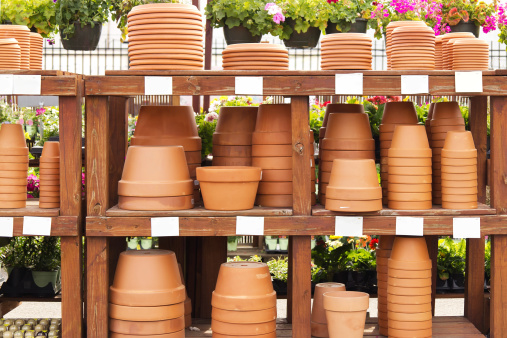 Stacks of terracotta pots on display outside with blank tags.