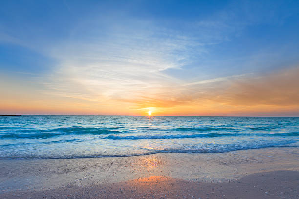 オーシャンビーチの夕日 - beach sun blue sky ストックフォトと画像