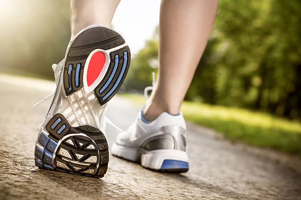 Stretching the feet "Young woman is warming up for jogging. Slightly toned, processed RAW in 16bit color mode." sole of shoe stock pictures, royalty-free photos & images