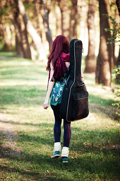 street musician walking with guitar case