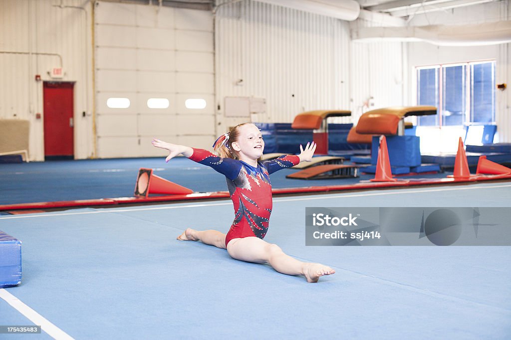 Young Gymnast Doing Floor Routine Color image of a level 5 gymnast practicing her beam routine. This image has motion blur and grain. Gymnastics Stock Photo