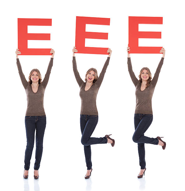 Woman holding letter E. Attractive woman holding big 3D letter E and smiling at camera. Isolated on white. Full length.People with letters and numbers concept. Look for other images from this series. Click on image below for lightbox. 3d red letter e stock pictures, royalty-free photos & images