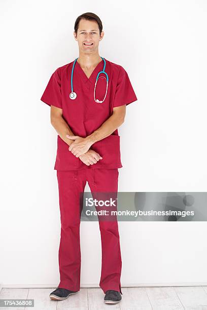 Studio Portrait Of Doctor Leaning Against White Background Stock Photo - Download Image Now