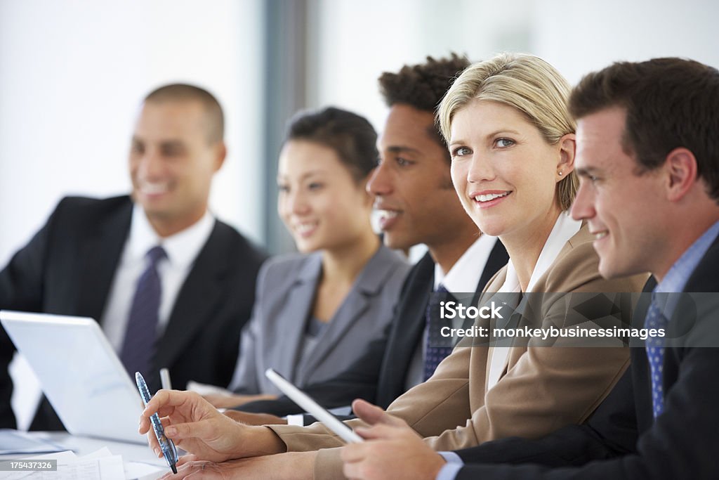 Portrait Of Female Executive Attending Office Meeting With Colle Portrait Of Female Executive Attending Office Meeting With Colleagues Smiling At Camera 20-29 Years Stock Photo