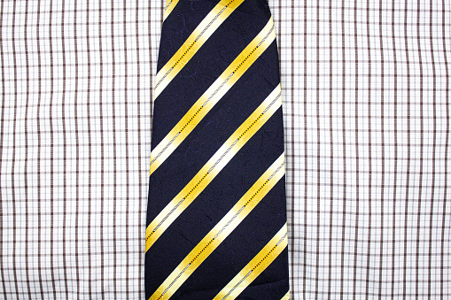 Men's classic shirt texture. Checkered shirt and tie with yellow stripes, office, festive look. Texture of shirt and tie.