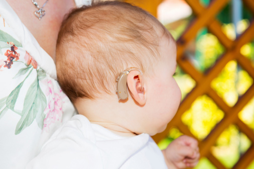 Cute baby boy wearing hearing aid