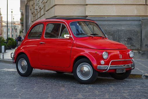 Siracusa, Ortigia, Italy: vintage, red Fiat 500 shown parked on a street in historic Ortigia, Sicily. The cinquecento is a city car produced by the Italian manufacturer Fiat between 1957 and 1975.