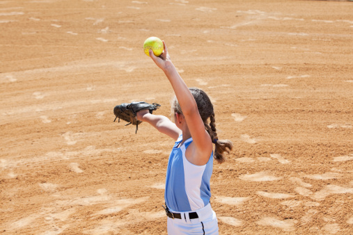 Left-handed fastpitch softball pitcher:  Girl (9 years) on mound.  Image shot from second base position looking in toward the plate.