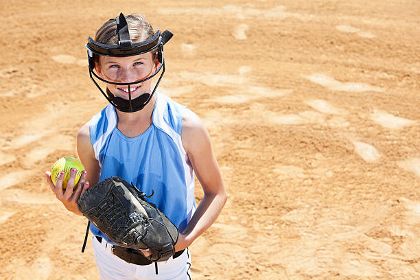 Softball player Girl (10 years) playing softball, wearing face mask (standard safety gear required by many leagues). baseball pitcher baseball player baseball diamond stock pictures, royalty-free photos & images