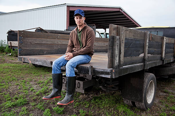Farmer sitting on back of truck