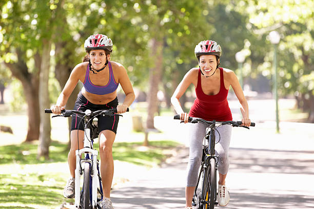 istock Two Women Cycling Through Park 175440103