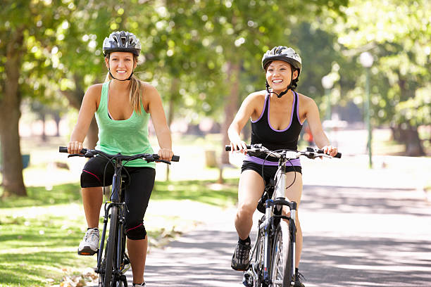 istock Two Women Cycling Through Park 175440111