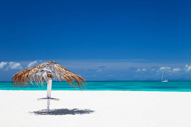 Tropical Getaway on Nassau Paradise Island, Bahamas - Palm Thatched Umbrellas and Sun Loungers on Pristine Beach with Ocean View