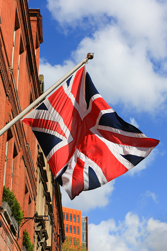 United Kingdom Flag floating on a London Building on a beautiful day.