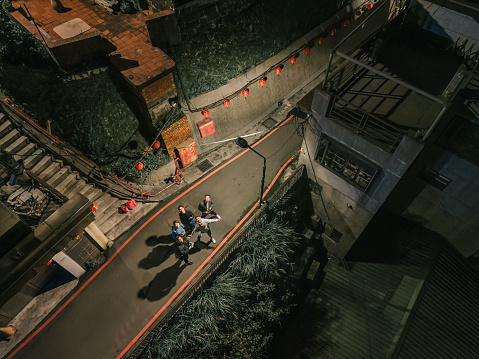 drone point of view Asian Chinese friends looking up from Jiufen, Taiwan at night