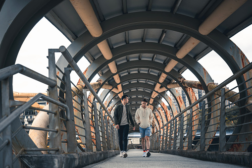 Asian Chinese gay couple tourist walking on pedestrian bridge in Taiwan