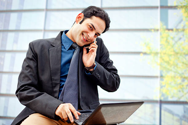 istock Indian Businessman on the phone and Using Laptop Office Building 175442532